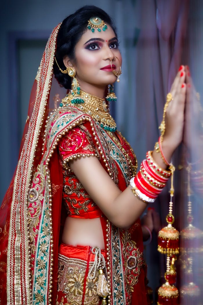 Stunning portrait of an Indian bride in vibrant red and gold attire.